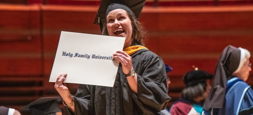 Woman holding diploma case at commencement