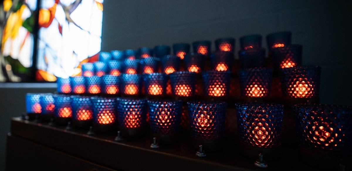 Votive candles burn in the chapel as a prayer offering