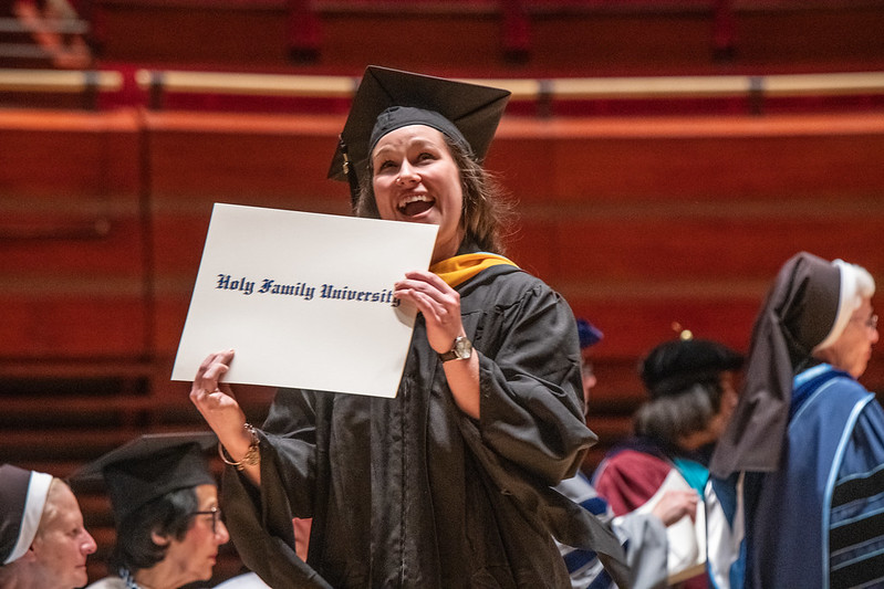 47950920537_50717beff5_c.jpg Girl holding Holy Family University diploma