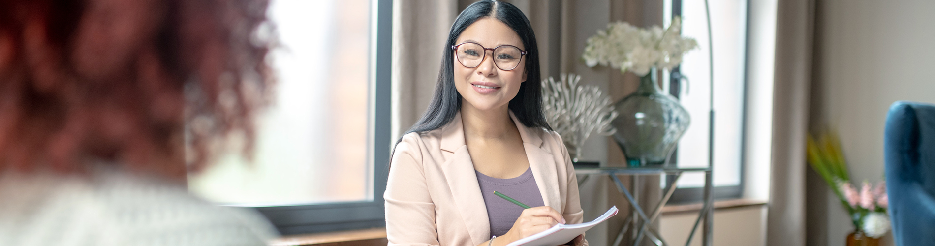 Counseling student speaking with a client while taking notes