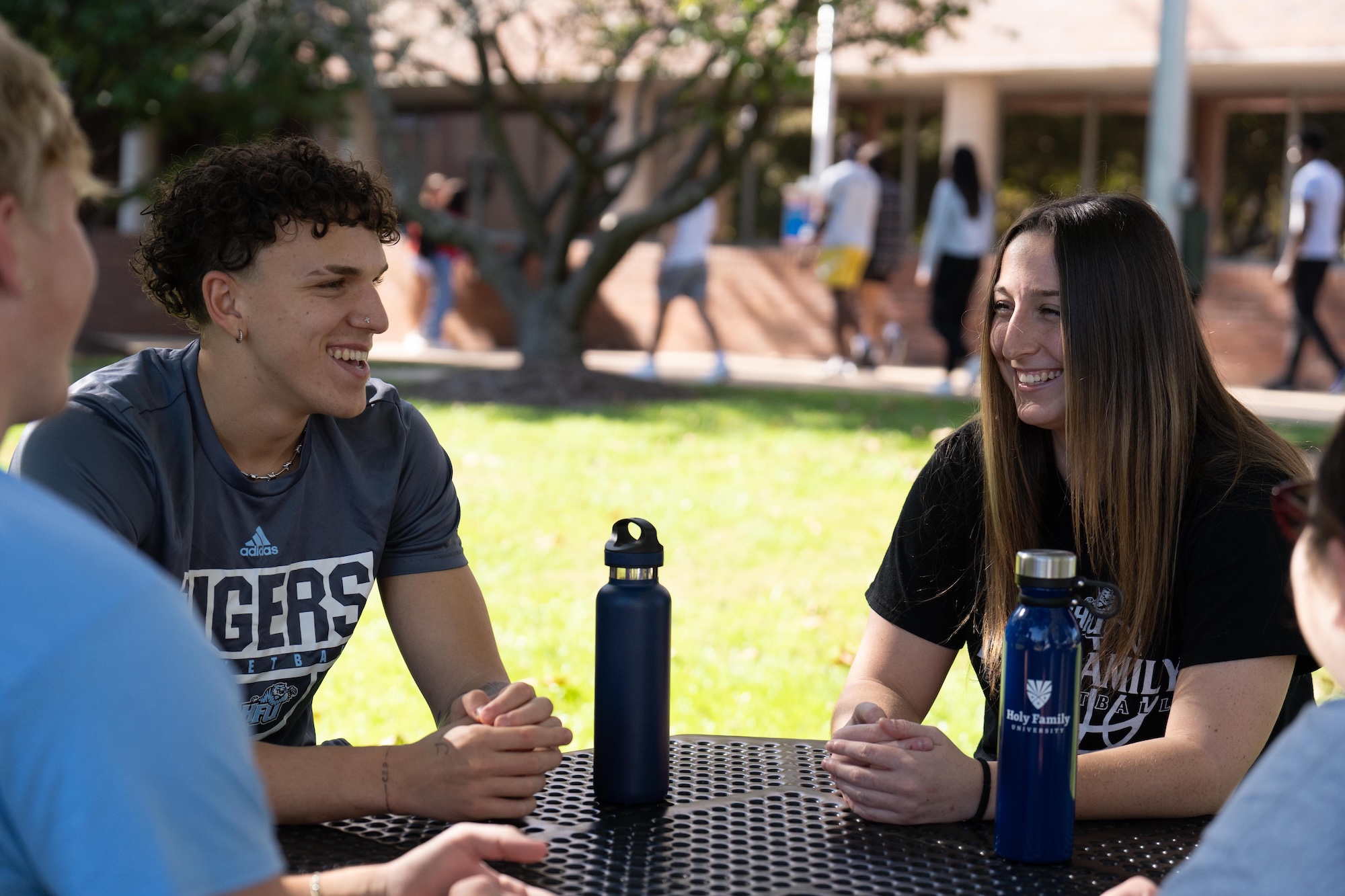 HFU students sitting at an outdoor table on campus