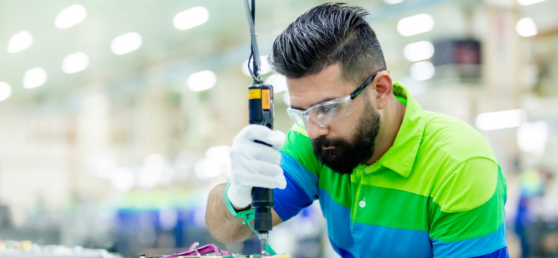 A worker in a manufacturing facility assembling a piece of machinery