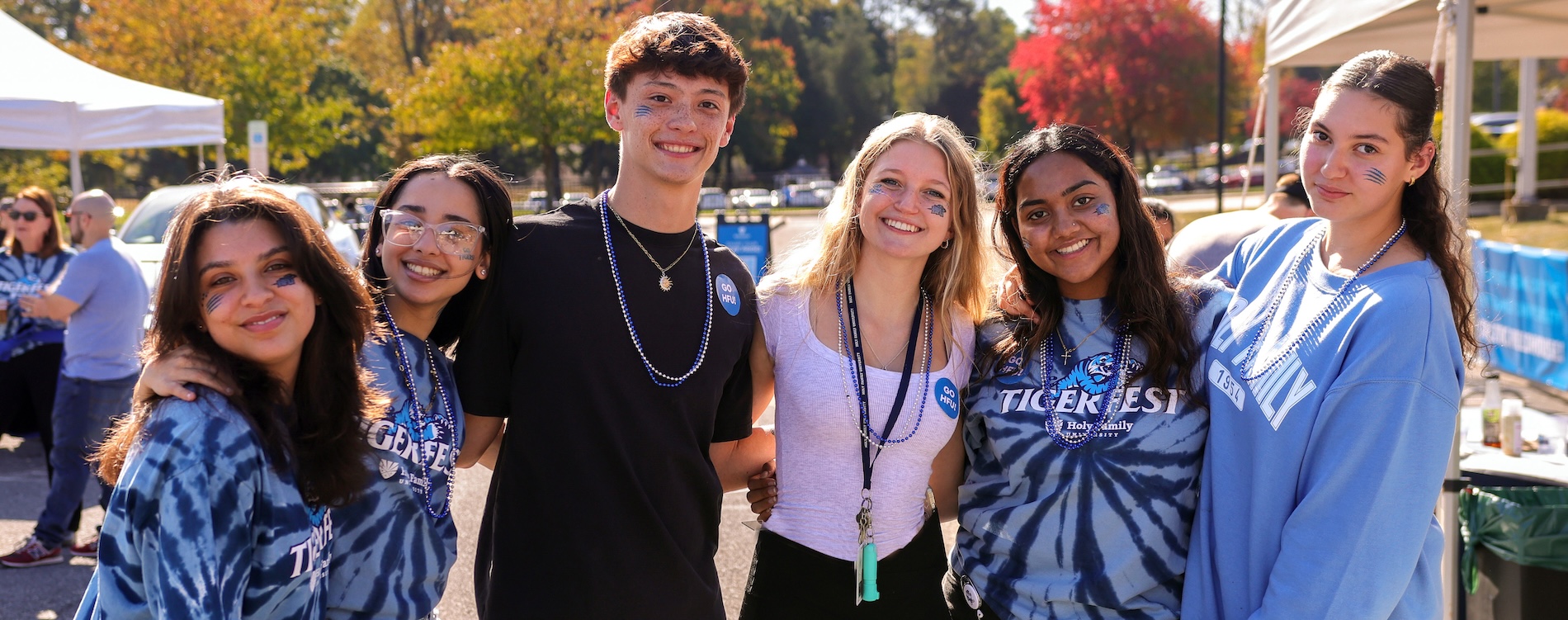 A group of students celebrate outside on campus at an event