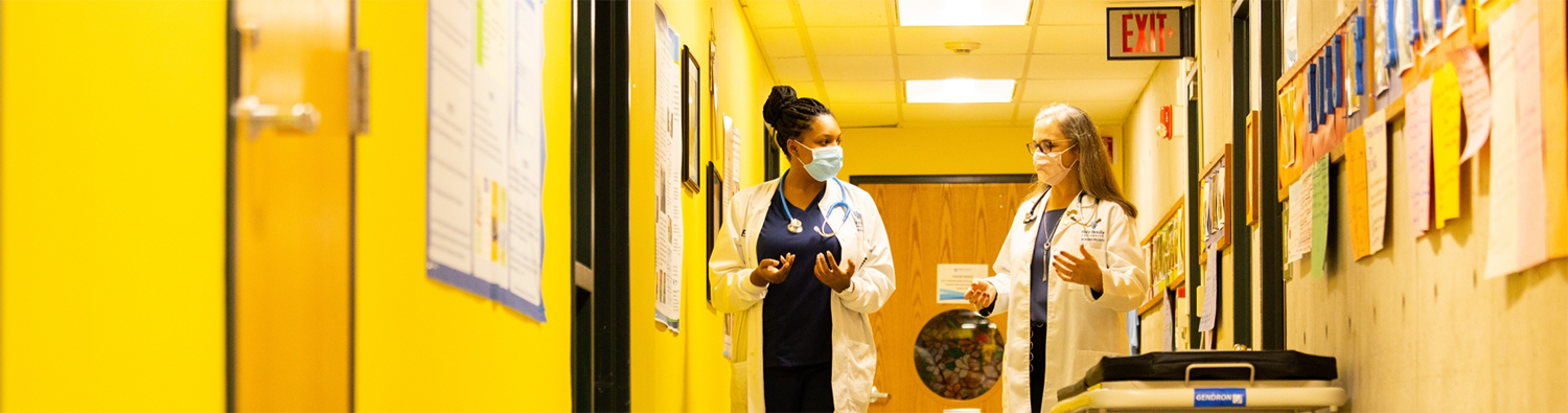 Dr. and student walk through Nursing Education Center