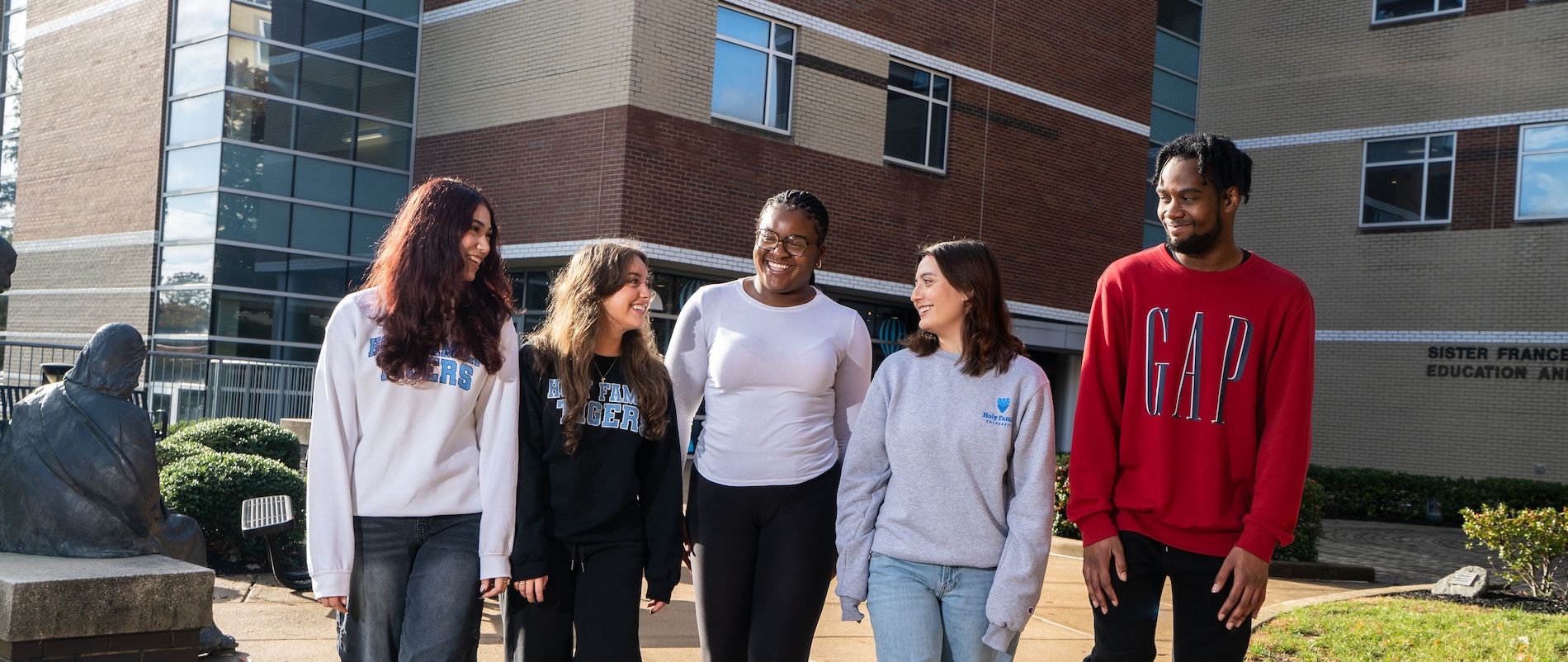 Five students outside the Library walking through campus