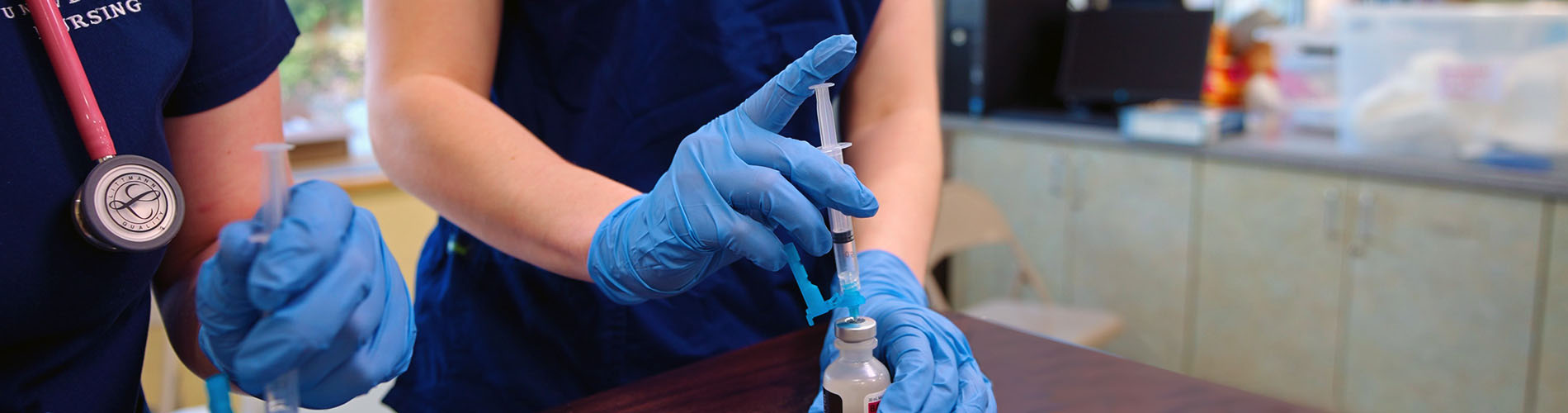 Close-up shot of the hands of two nursing students working together during training.