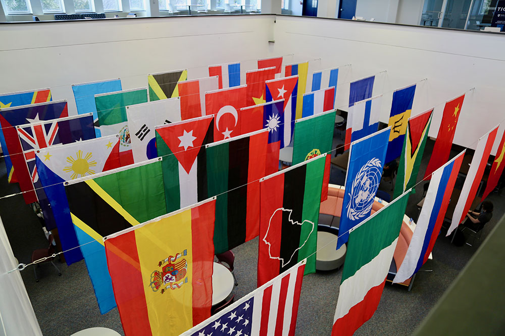 A large collection of international flags displayed in an HFU building