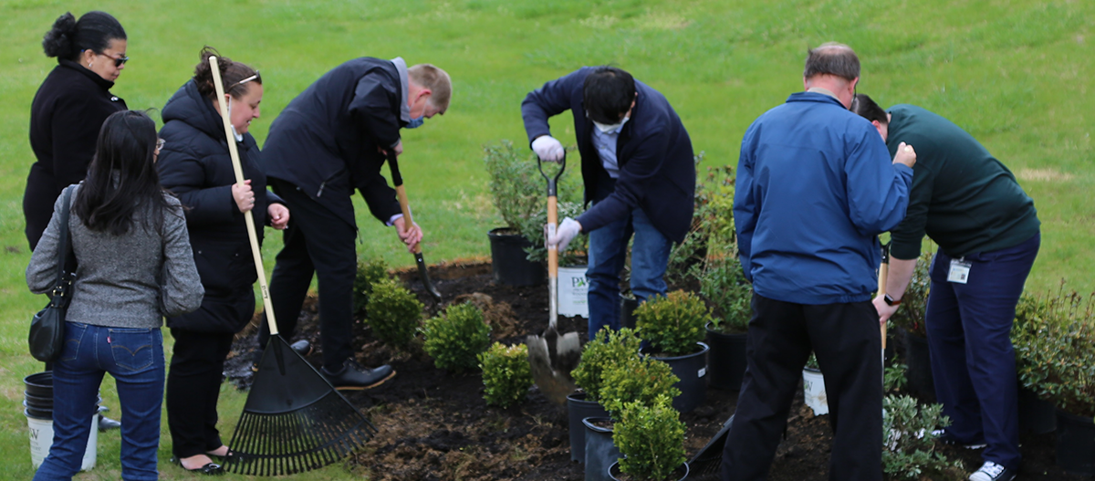 Members of the University engage in the groundbreaking of the University’s new Reflection Garden.