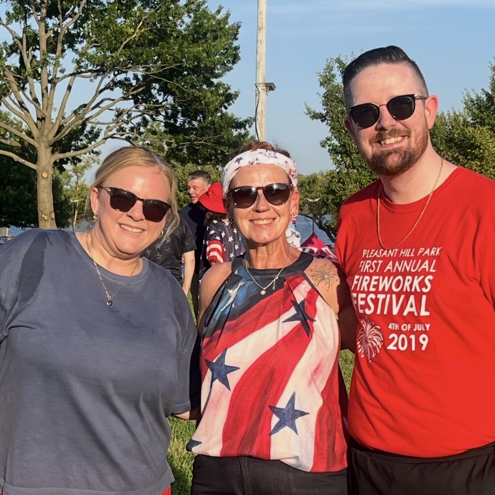 Three people smiling in the sunshine at FreedomFest