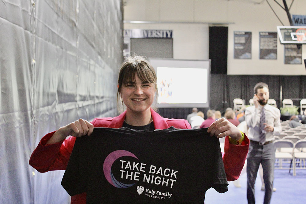 An attendee holding up a Take Back The Night t-shirt