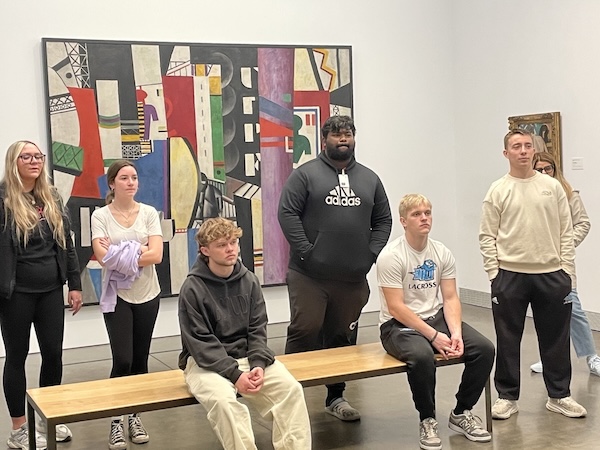 Students at the Philadelphia Art Museum listening and enjoying the art during a guiding tour
