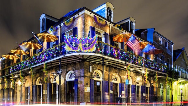 An iconic New Orleans building with lights and decorations set up for Mardi Gras