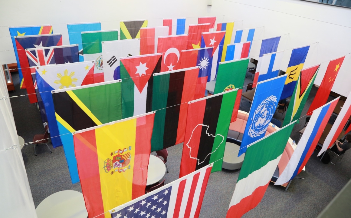 A display of international flags hanging in a building lobby