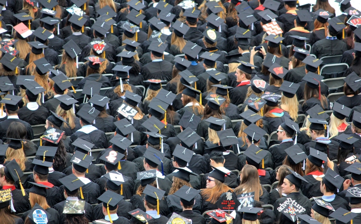 An aerial image of a graduating class of college students, which looks like a sea of graduation caps