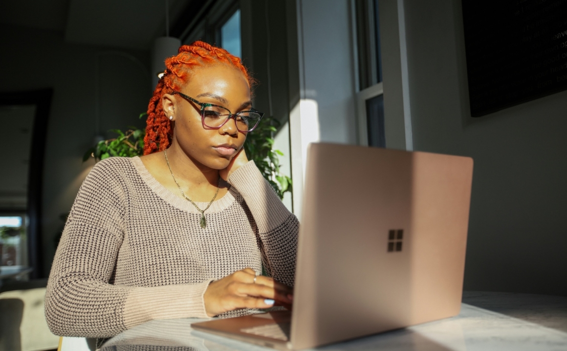 A woman working on a laptop while staring intently at the screen