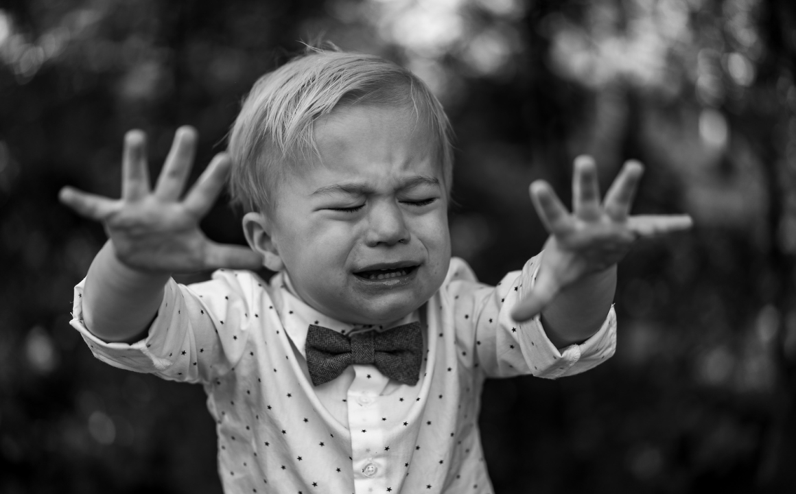 A toddler in a looking upset with tears in his eyes