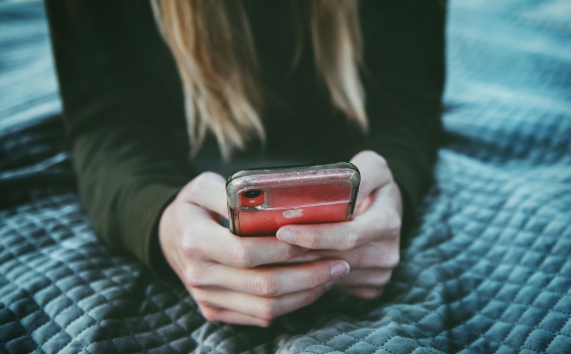 Girl with focus on her hands holding her phone and scrolling