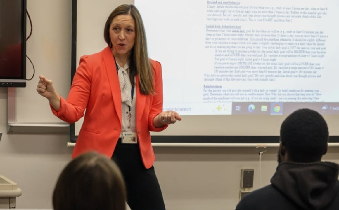Dr. Katharine Croce delivering a lecture at the head of her classroom