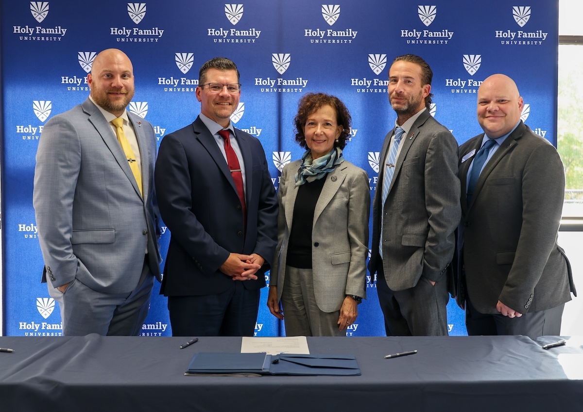 Dr. Prisco, President of Holy Family, with Father Judge & HFU stakeholders, signing the agreement
