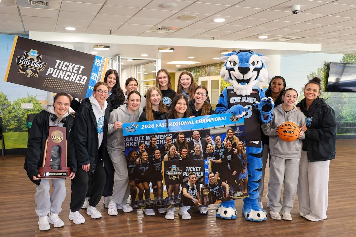 Women's Basketball team celebrating historic victory back on campus