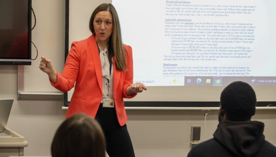 Dr. Katharine Croce delivering a lecture at the head of her classroom