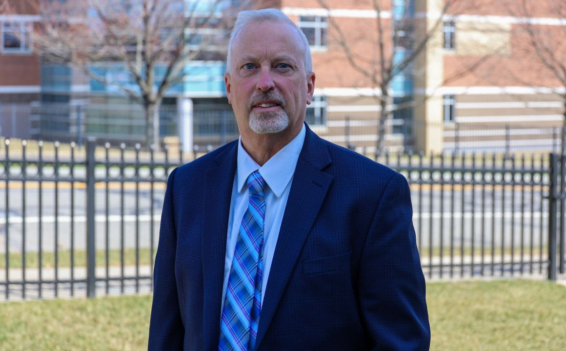 Tobin Porterfield, Ph.D. standing outside on the Holy Family campus