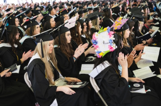 The crowd of students at Commencement, sitting in caps and gowns