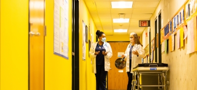 Dr. and student walk through Nursing Education Center