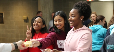 Students enjoying cake at a student event