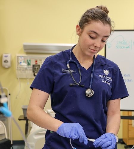 A Holy Family nursing student practicing a procedure in a simulation lab