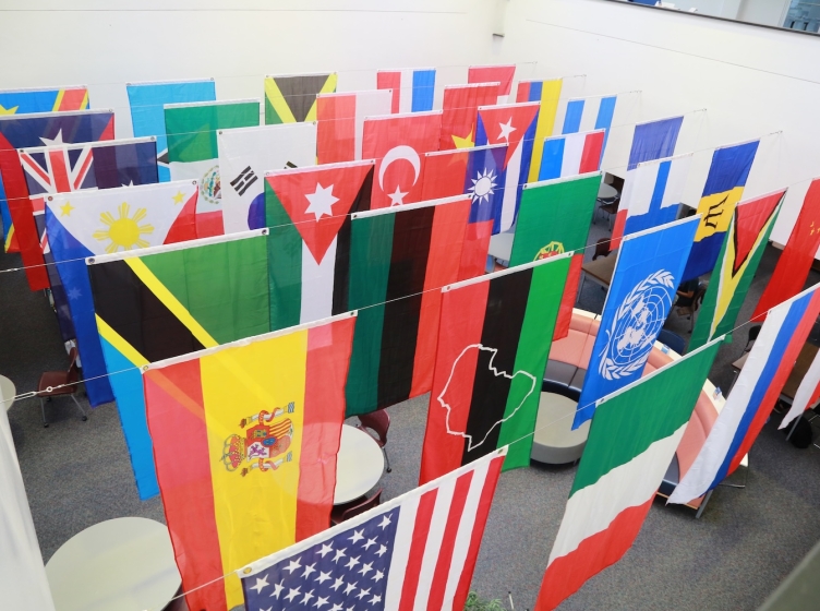 A display of international flags hanging in a building lobby