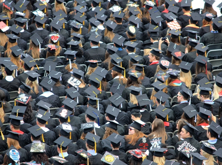 An aerial image of a graduating class of college students, which looks like a sea of graduation caps