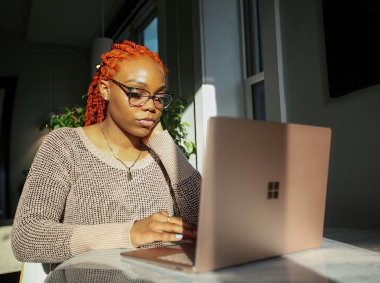 A woman working on a laptop while staring intently at the screen