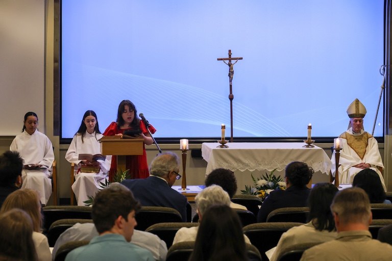 A student speaking at a lectern during mass