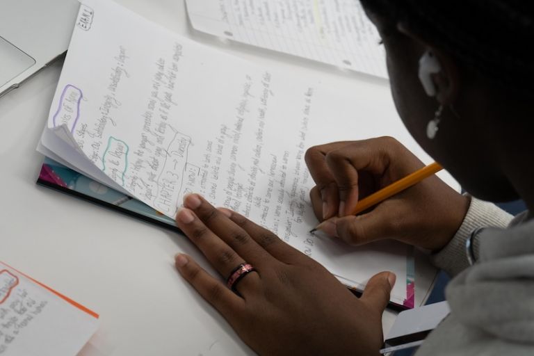 A student taking handwritten notes while studying
